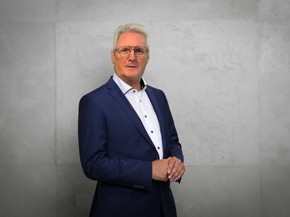John Großpietsch im Business-Outfit vor neutralem Hintergrund – Ansprechpartner für moderne Gutscheinsysteme, Arbeitgeberkarten und Loyalty-Lösungen.